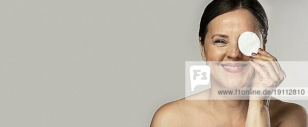 Glückliche reife Frau posiert mit Wattebausch Make up Entfernung Kopie Raum