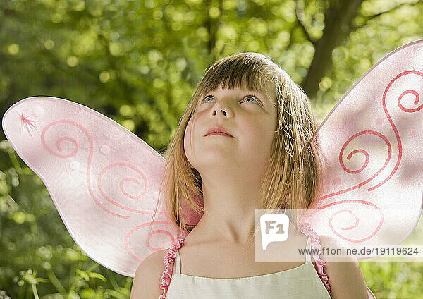 Girl in a pink fairy costume looking up