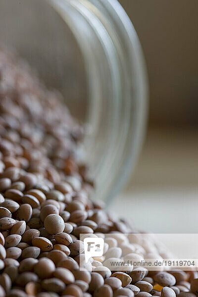 Close up of lentils pouring out of glass jar