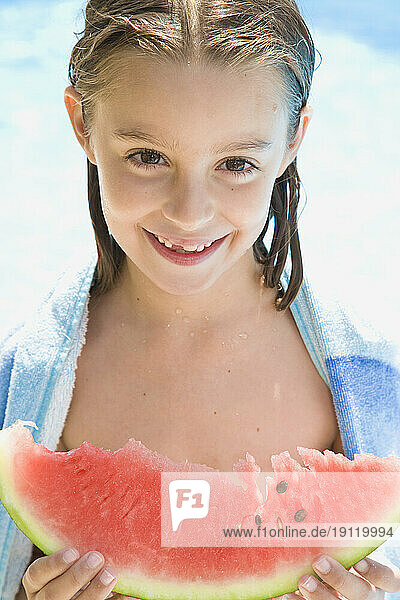 Smiling young girl holding water melon