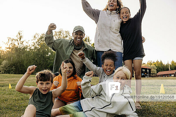 Fröhliche Kinder feiern mit Betreuern auf dem Spielplatz