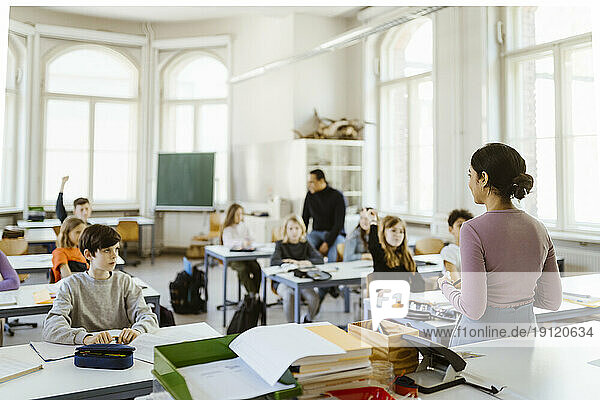 Lehrerin unterrichtet Schüler im Klassenzimmer sitzend