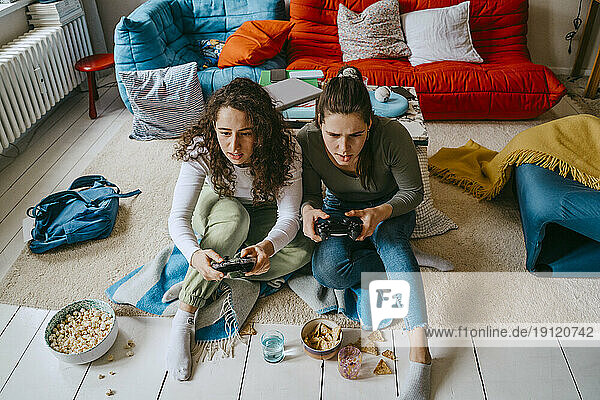 Junge Freundinnen spielen ein Videospiel im Wohnzimmer zu Hause