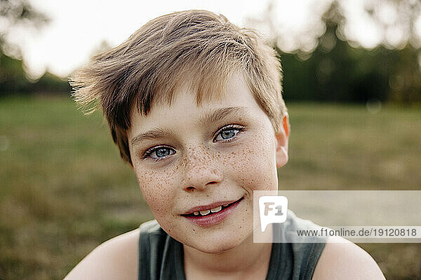 Porträt eines lächelnden Jungen mit grauen Augen