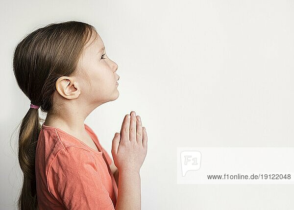 Schönes kleines Mädchen betet mit Kopierraum