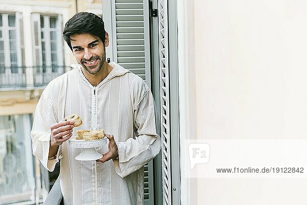 Eid al fitr Konzept mit muslimischem Mann beim Essen