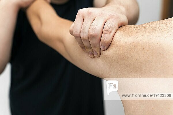 Vorderansicht Physiotherapeutin massiert Arm eines Mannes
