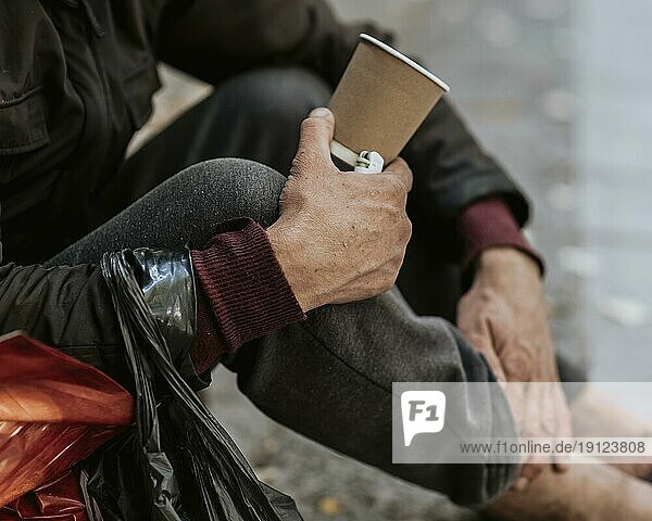 Seitenansicht Obdachloser Mann hält Tasse