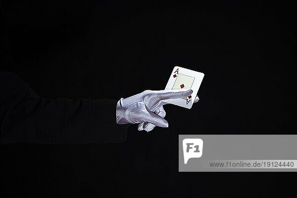 Magier hält Asse spielen Karte Finger gegen schwarzen Hintergrund