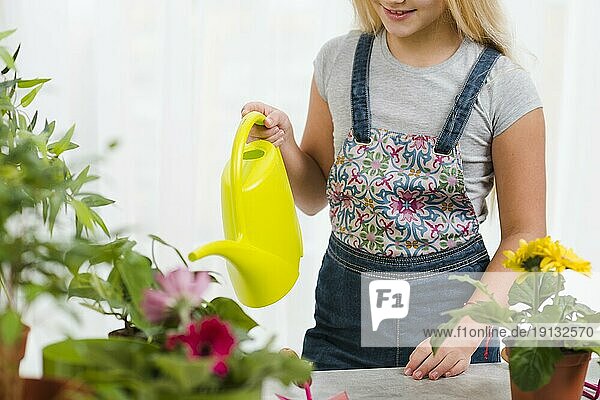 Close up young girl watering flowers