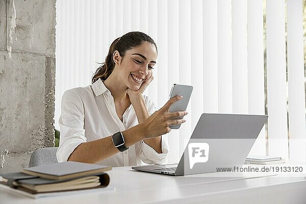 Seitenansicht smiley Geschäftsfrau mit Smartphone Laptop