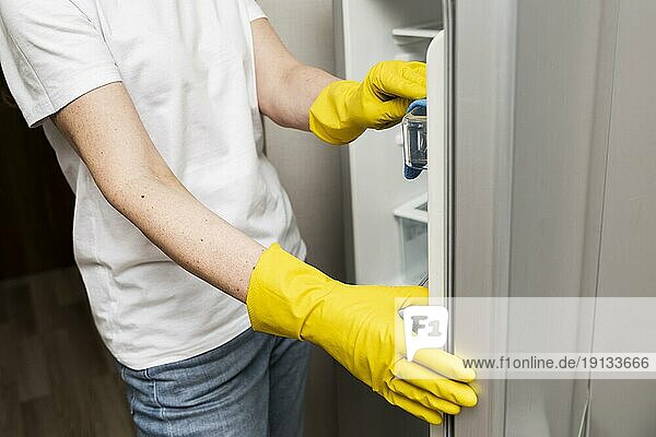 Seitenansicht Frau beim Reinigen des Kühlschranks