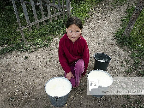 Kleines Mädchen mit frisch gemolkener Milch in Eimern  Razdolnoe  Kirgistan  Asien