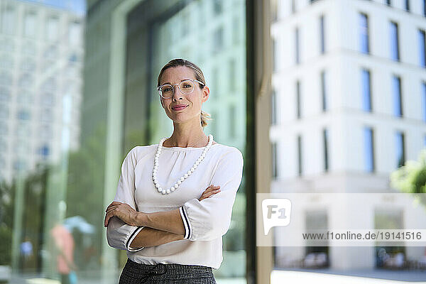 Smiling businesswoman standing in front of building