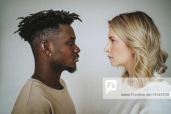 Couple looking at each other against gray background