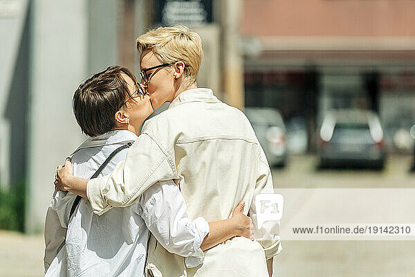 Affectionate lesbian couple kissing at sunny day