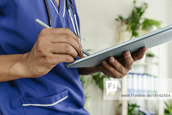 Doctor using tablet pc at healthcare clinic