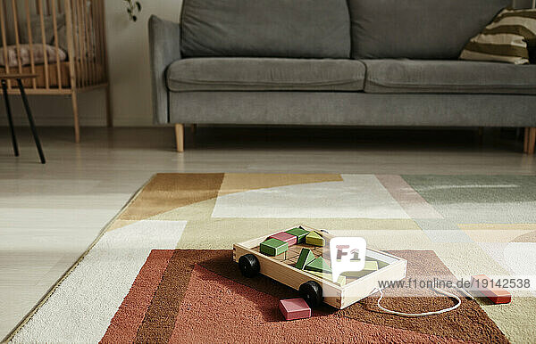 Wooden toy cart on carpet in living room at home
