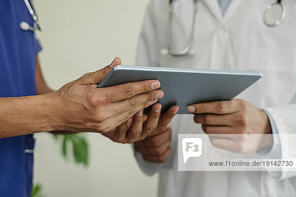 Doctors discussing over tablet PC at healthcare clinic