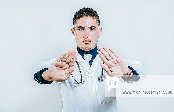 Arzt macht eine Stoppgeste mit Handflächen auf weißem Hintergrund. Lateinischer Arzt macht eine Stoppgeste mit seinen Händen isoliert