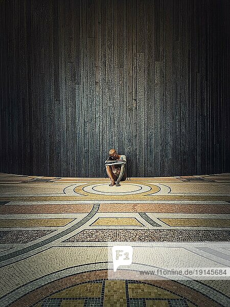 Paris  Frankreich  18. November 2022. Akt von Ugo Rondinone und Ausstellung im Petit Palais. Einsame menschliche Statue als sitzender Mann auf dem Boden vor dem Hintergrund einer Holzwand  Europa