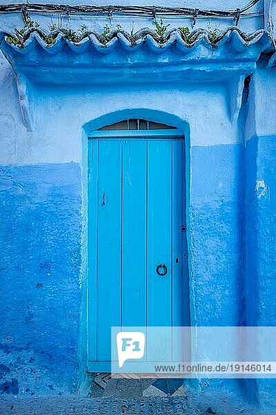 Blaue Tür an einer blaün Steinmauer in Chefchaouen  Marokko  Afrika