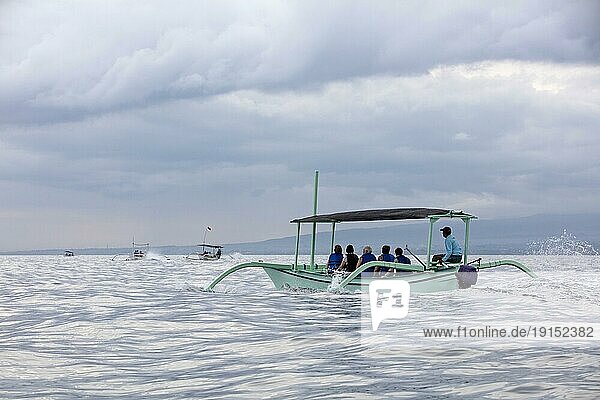Einheimische Fischer in traditionellen Auslegern mit Touristen bei einer Delphinbeobachtungstour am Lovina Beach  Buleleng Regency auf der Insel Bali  Indonesien  Asien