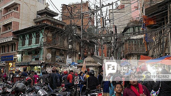 Menschenmenge  viele Menschen  Straßenszene am späten Nachmittag im Viertel vom Basar  Gewirr von elektrischen Leitungen  Kathmandu  Nepal  Asien
