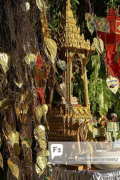 Traditioneller thailändischer Buddha Altar als Busabok mit Geld und Räucherstäbchenopfern  bunten Lanna Laternen. Bodhibaum mit goldenen Blättern mit Wünschen und Versprechen in vielen Sprachen. Selektiver Fokus  unscharfer Hintergrund. Goldener Berg  Bangkok  Thailand  Asien