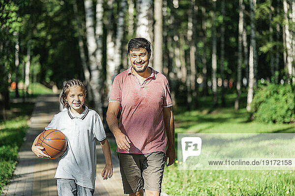 Smiling father and son walking together in park