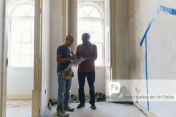 Architect and builder discussing together at construction site