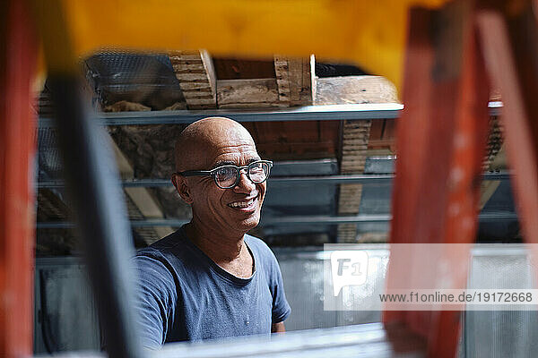 Happy construction worker wearing eyeglasses at site