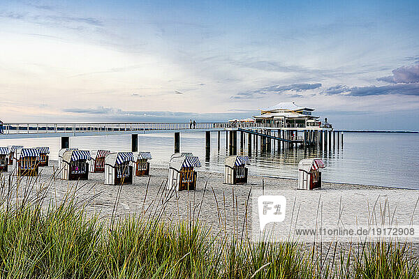 Germany  Schleswig-Holstein  Timmendorfer Strand  Hooded beach chairs with pier and Mikado tea house in background