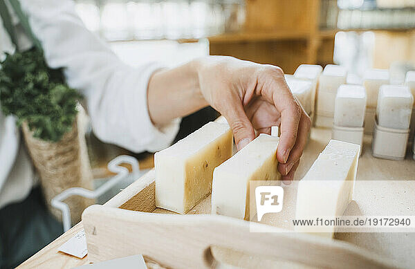 Hand of woman picking scented soap in shop