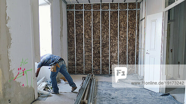 Construction worker working in front of insulation wall at site