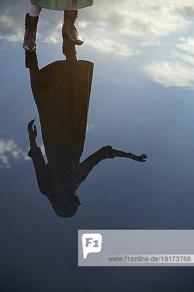 Reflection of woman in water puddle