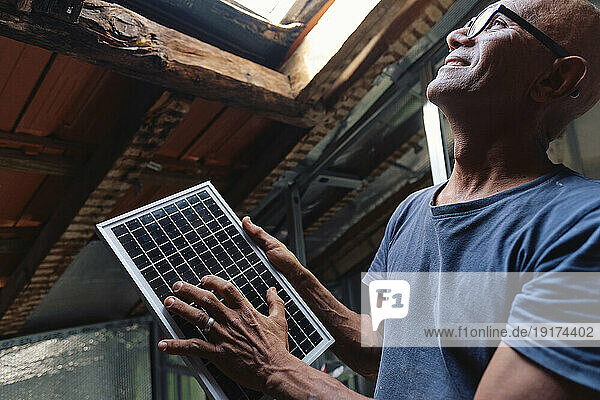 Happy construction worker with solar panel at site