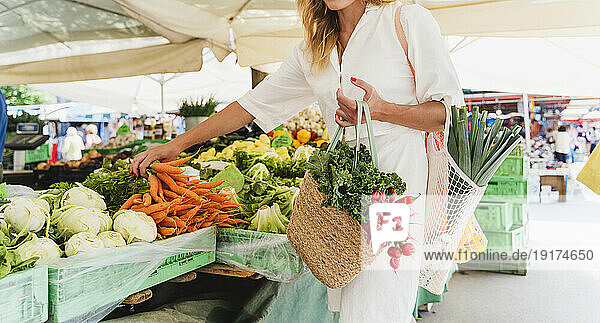 Woman buying carrots in farmer's market