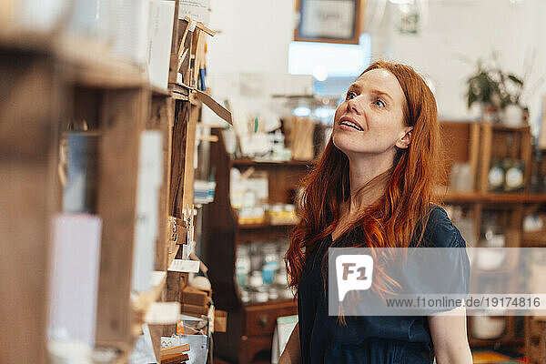 Smiling redhead woman shopping at store