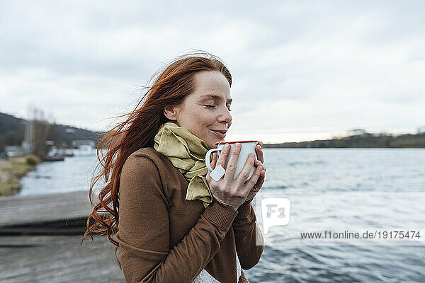 Woman having tea by lake