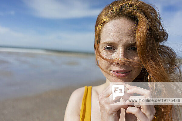 Woman with wind in hair at beach on sunny day