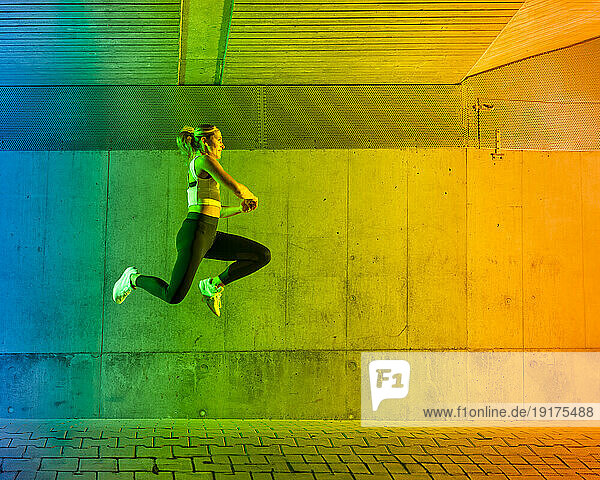 Woman jumping in front of wall