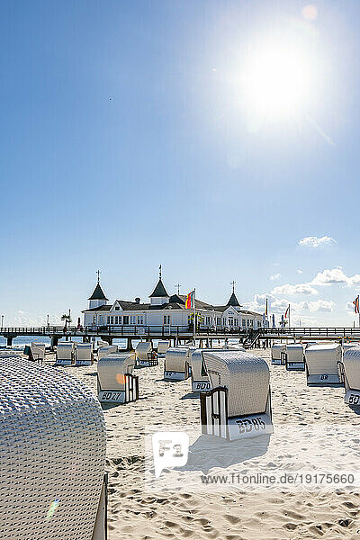 Germany  Mecklenburg-Vorpommern  Ahlbeck  Sun shining over hooded beach chairs with bathhouse in background
