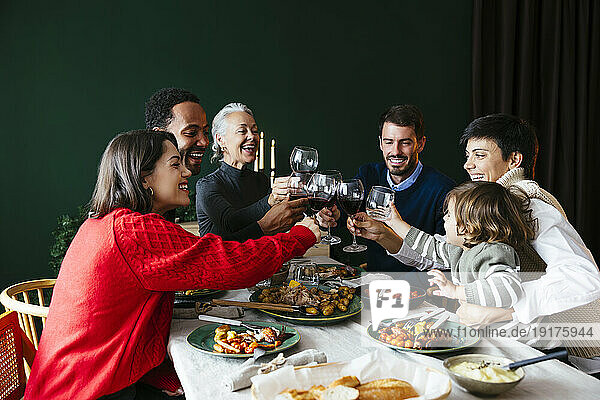 Happy family toasting wineglasses in dining room at home