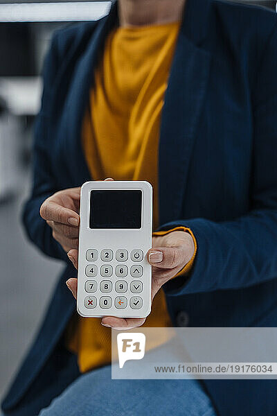 Hands of businesswoman holding modern credit card reader