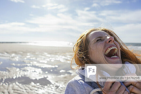 Woman laughing at beach on vacation