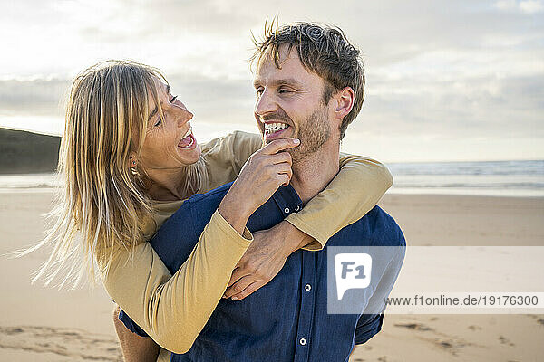 Cheerful woman enjoying with man at beach