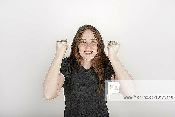 Porträt einer jungen rothaarigen Frau  feiernd  glücklich  mit einem gewinnenden Ausdruck  auf reinem Hintergrund