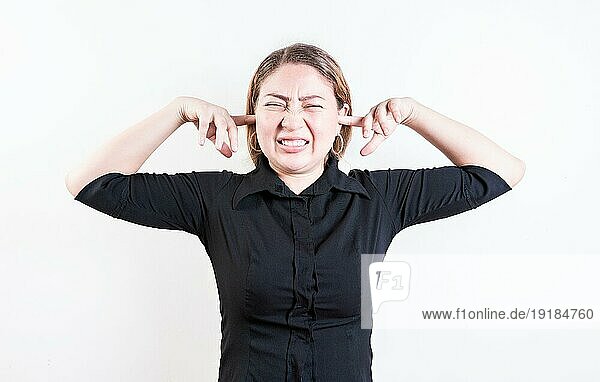 Unzufriedene junge Frau  die sich die Ohren zuhält  isoliert. Lateinisches Mädchen hält sich die Ohren zu  isoliert
