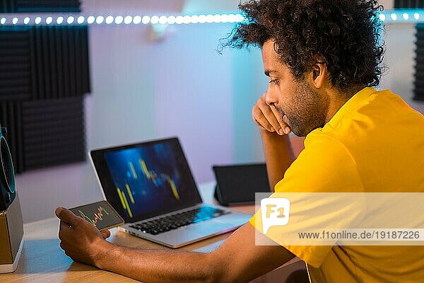 Junger Mann macht Kryptowährungsgeschäft Handel auf dem Computer zu Hause in der Nacht